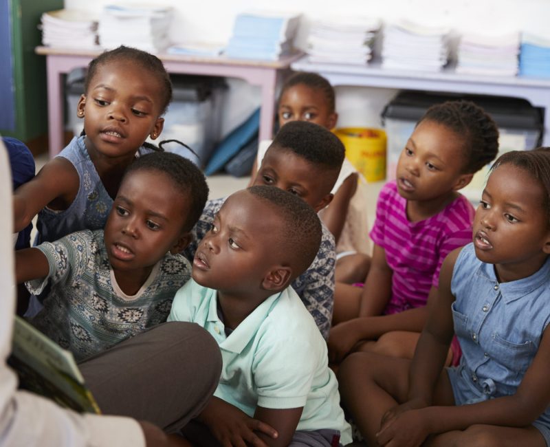 Teacher reading book to elementary school children in class