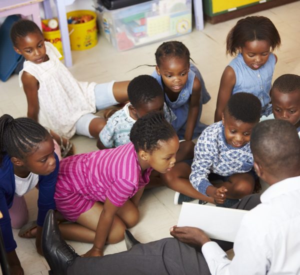 Teacher reading kids a book in an elementary school lesson